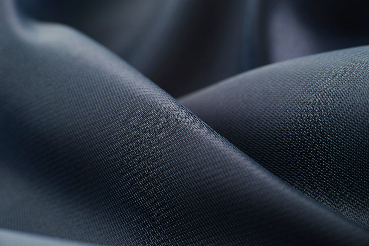Close-up of premium navy woven fabric draped in soft folds